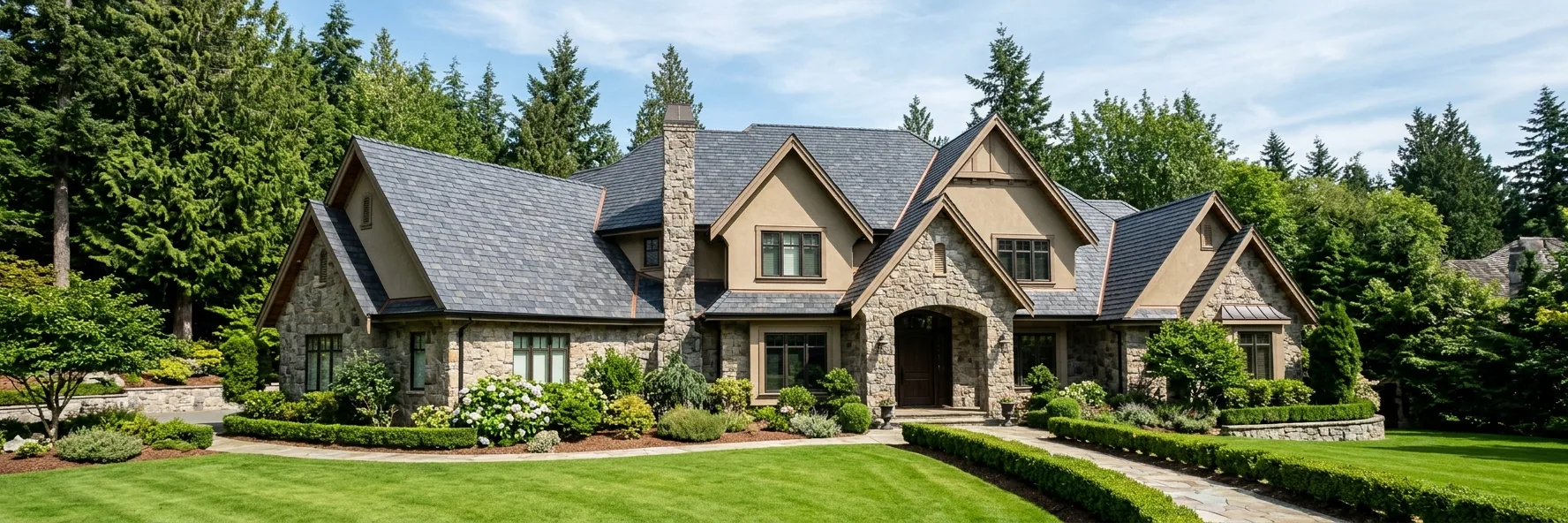 Stone estate home with a charcoal synthetic slate roof